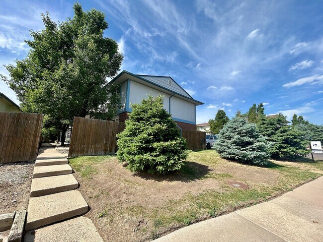 Charming suburban home with lush greenery and a clear blue sky, offering tranquil living in a picturesque neighborhood. - 10756 West 12th Lane