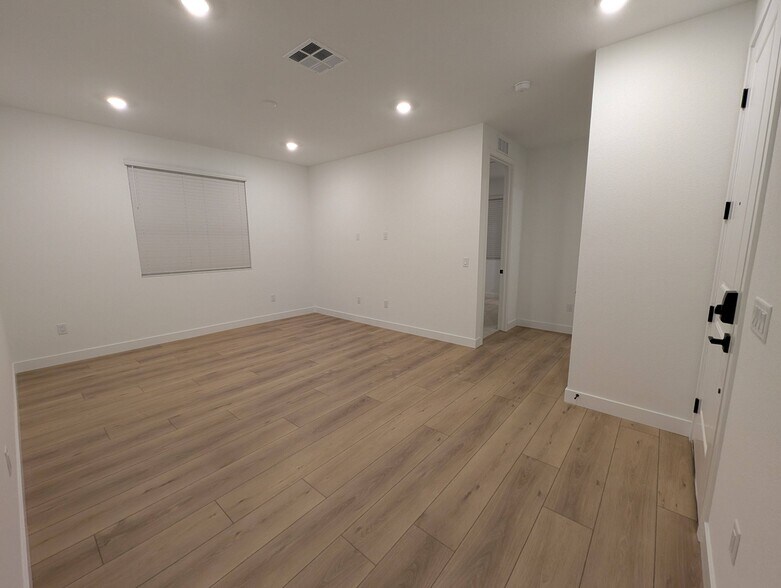 Large 18' x 13' living room with modern plank flooring and large window - 628 S Cecita Wy