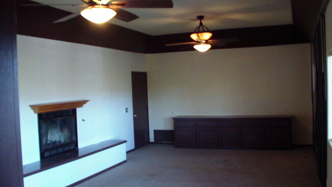 Large 28' x 15' living room. 10' high ceiling with gas fireplace and ceiling fan. - 2373 Mountain View Dr