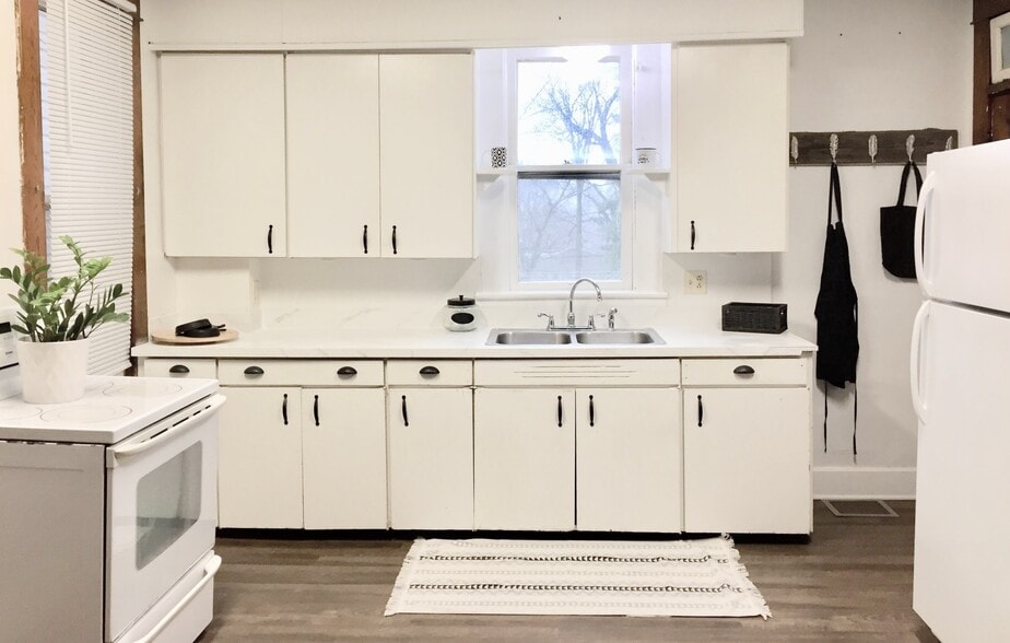 The kitchen has real wood cabinets, flat top electric stove, and fridge. First floor laundry room is just off the kitchen. - 328 E Walnut Street