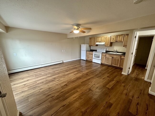 Explore this cozy apartment featuring a modern kitchen with stylish cabinetry and an inviting living area. - The Kimberly Apartments