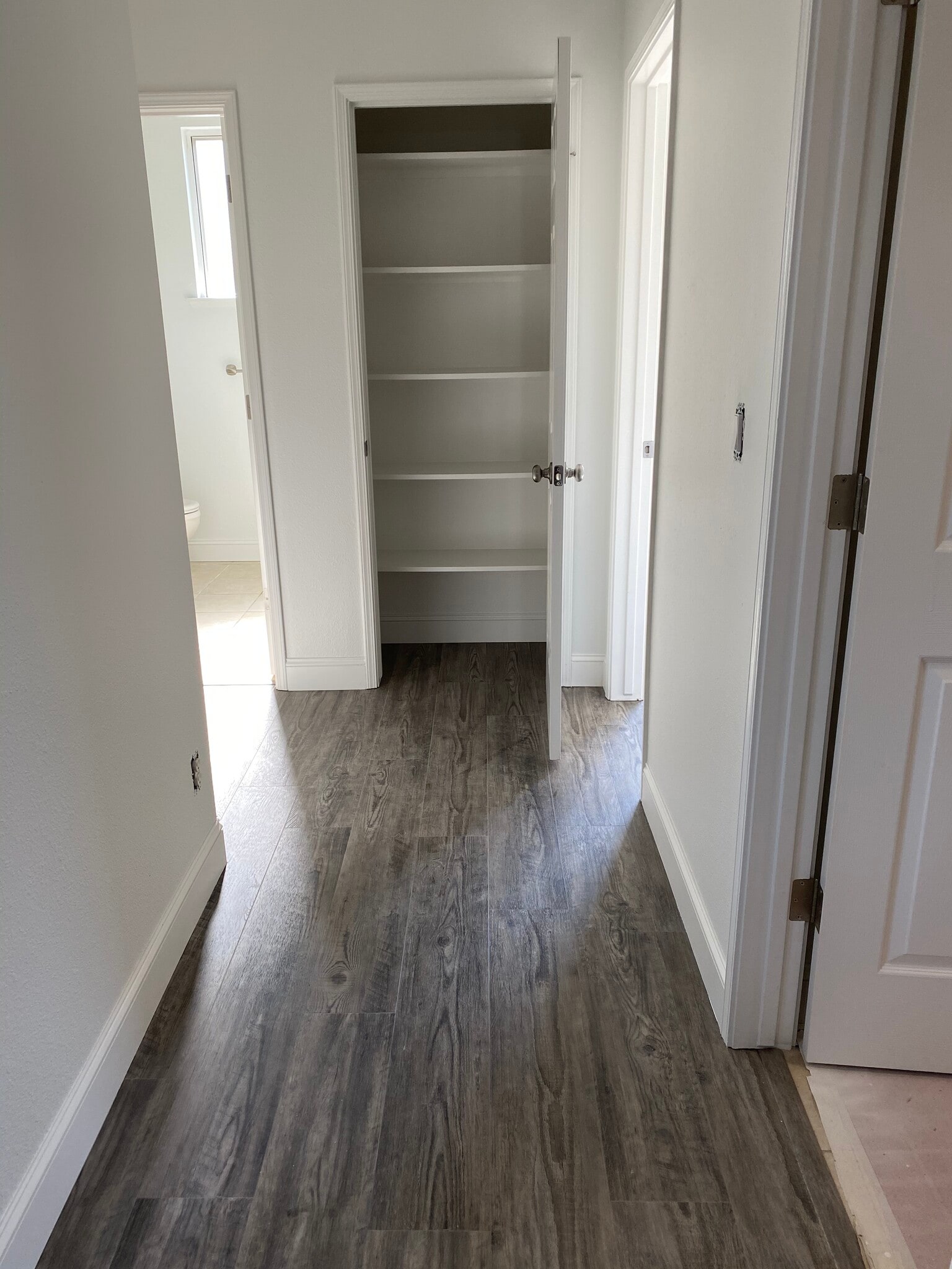 Hallway view; with closet open. 1 of 3 hallway storage closets - 1134 Pine Ct