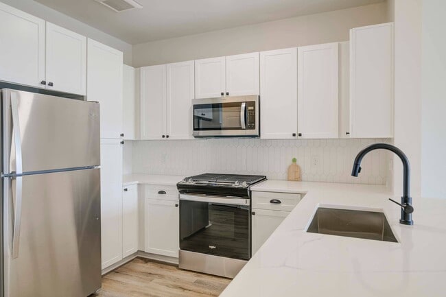 White cabinetry, backsplash, and stainless steel appliances - Terraces on the Hudson