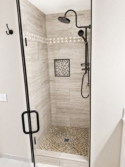 Updated walk-in shower with tile, rainfall shower head, and built-in niche. - 339 E Taft Ave