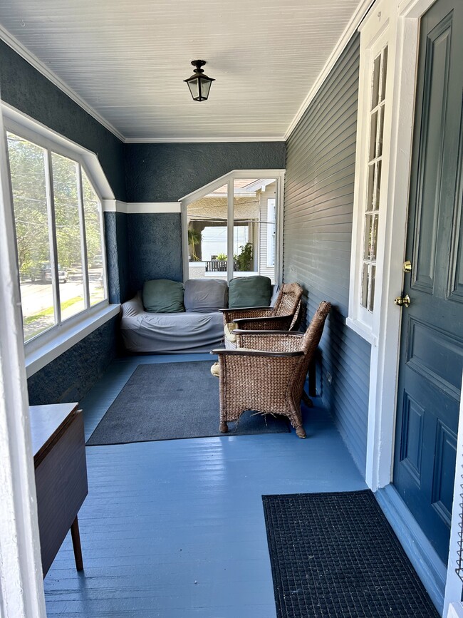 Large front porch can be redecorated to be cuter but the guys seem to like the sofas. - 2427 Calhoun St