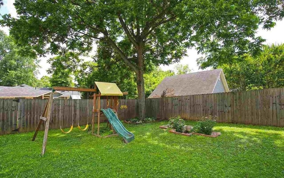 The fenced backyard can be accessed from the covered deck off the kitchen, the Carriage style doors off the basement, or from the alley - 903 Highland Rd