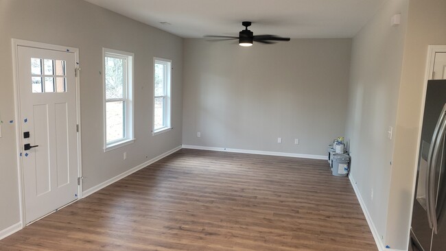 Living room open floor plan to kitchen with ceiling fan and laminate flooring - 203 Payne St