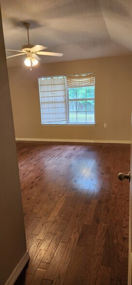 Master bedroom hard wood floors, tray ceiling and double window view of back yard - 2318 Tall Oak Dr
