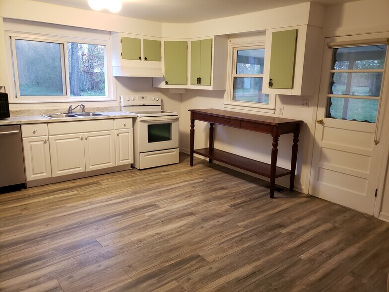 Large eat-in kitchen has new vinyl flooring and door to the covered patio. - 10106 Wingfield Rd