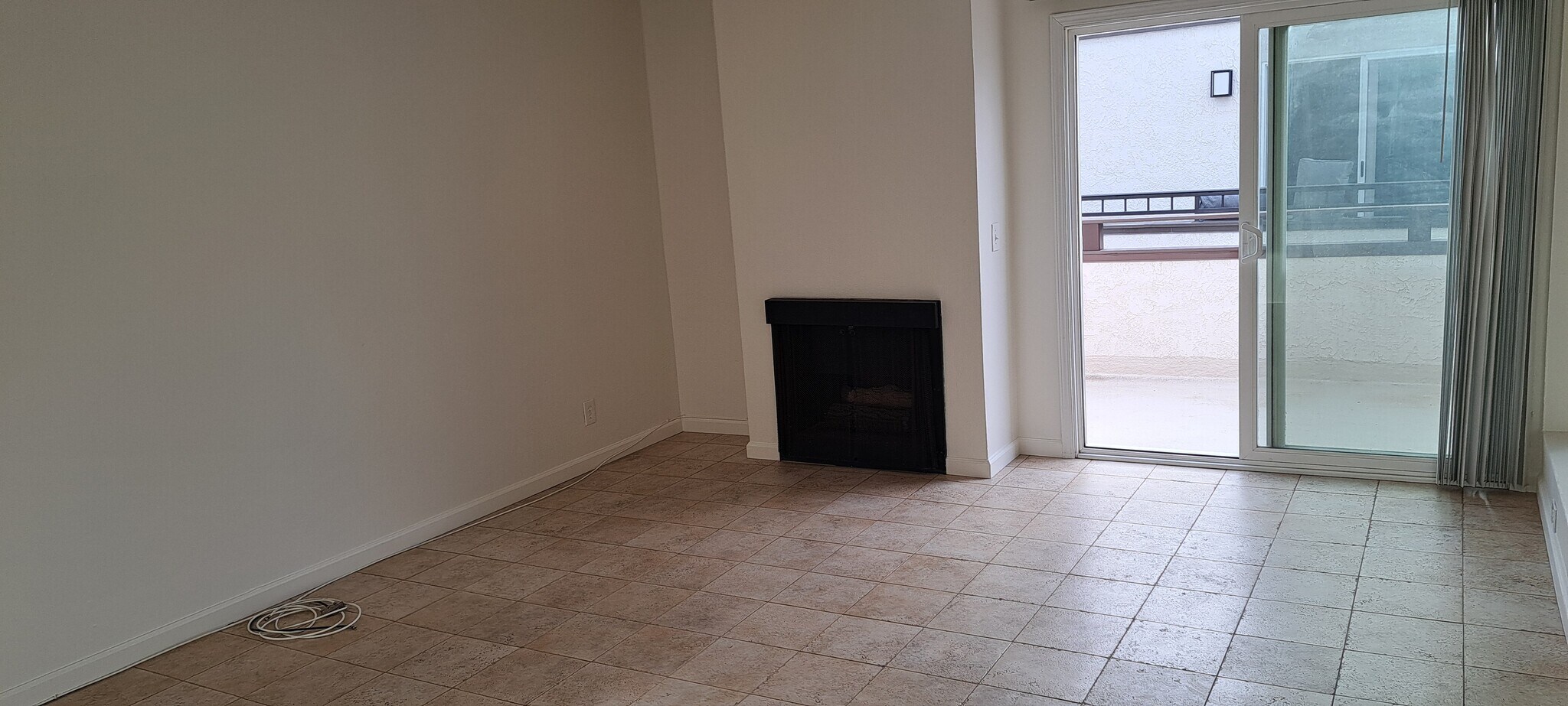 LIVING ROOM WITH FIREPLACE AND SLIDER TO BALCONY, TRAVERTINE STYLE PORCELAIN TILES - 314 20th St