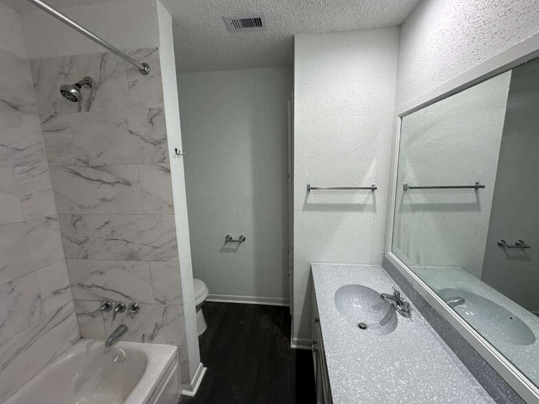 Primary Bathroom: Double vanity, soaking tub, and linen closet. - 7700 Creekbend Dr