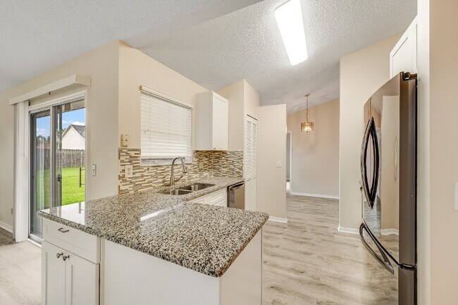 Building Photo - Spacious 3/2 with split plan and large fenced yard!