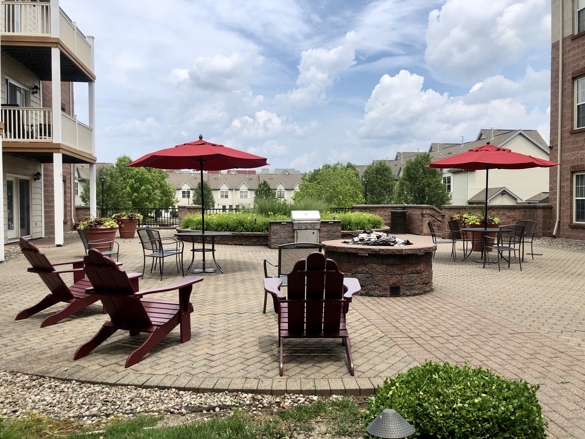 Courtyard w/ grilling station and electric fire pit - 200 East Avenue Apartments and Townhomes