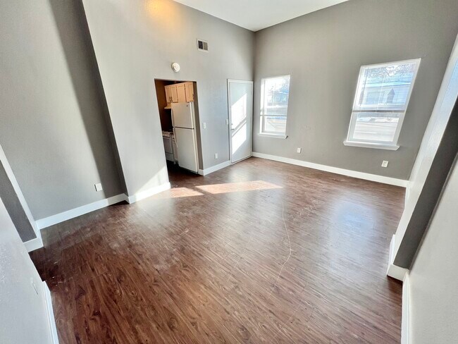Experience modern living with this spacious and bright room featuring sleek hardwood flooring. - Williams Street