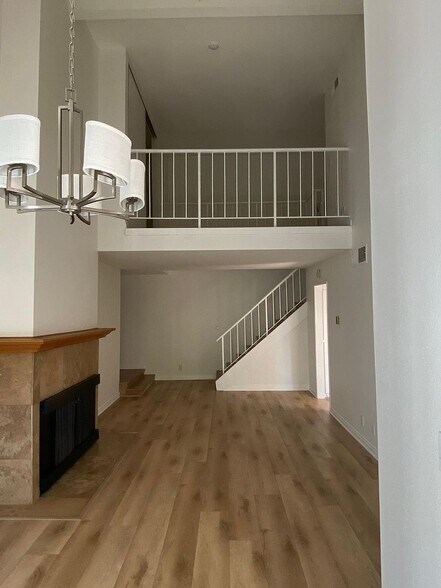 Living room with chandelier and fireplace - 8305 Summertime Ln