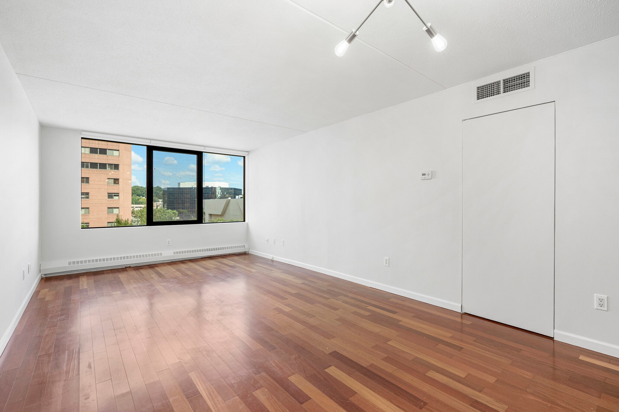 Wide windows open to view of trees and sky. Newly installed custom roller shades, too. - 4 Martine Ave