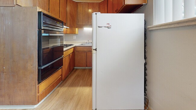 Experience the warmth of this charming kitchen designed for practicality and style. - Harmony Apartments