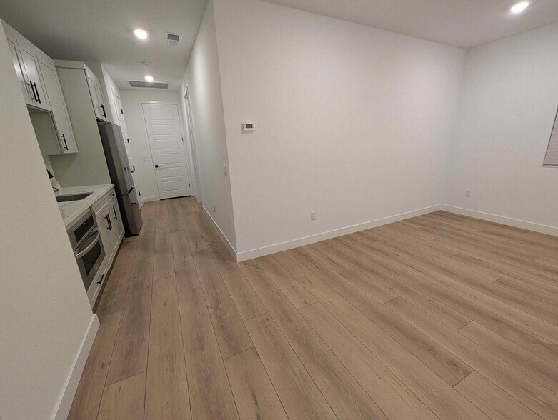 Entry door, kitchenette, and 18' x 13' living room with modern plank flooring - 628 S Cecita Wy