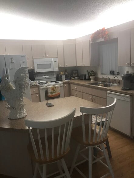 open kitchen looks out to large tiled, enclosed lanai - 9735 SE 176th St