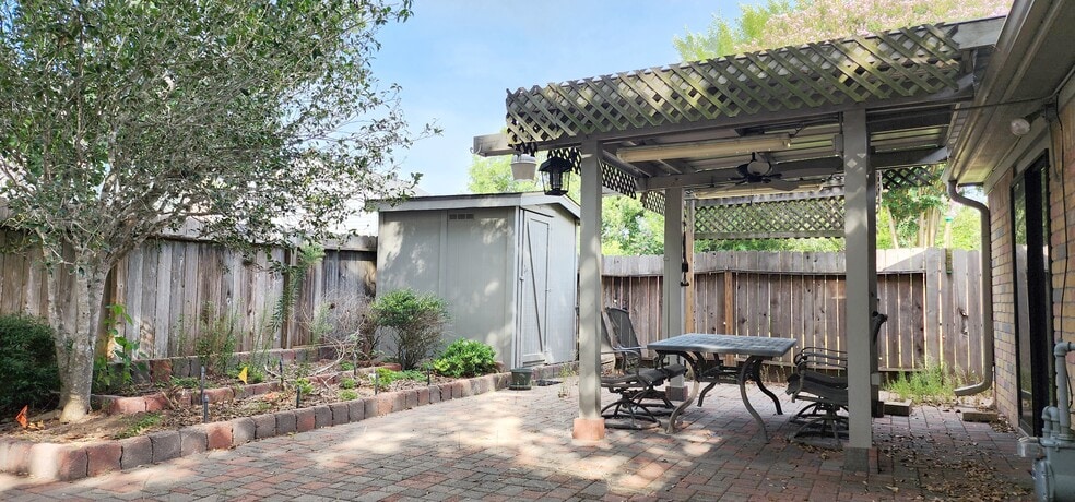 Covered patio with complementary furnished patio table and chairs. Shed in background for storage - 4722 Rainbow Run
