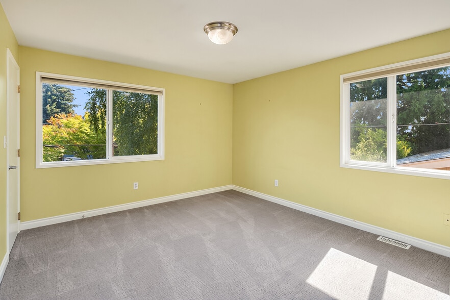 Light and bright bedroom with plenty of East facing windows. - 7051 8th Ave NW