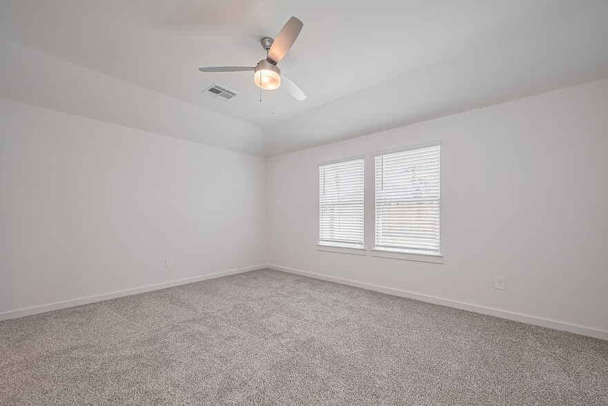 Primary bedroom with large windows overlooking backyard - 1535 Merulana Ln