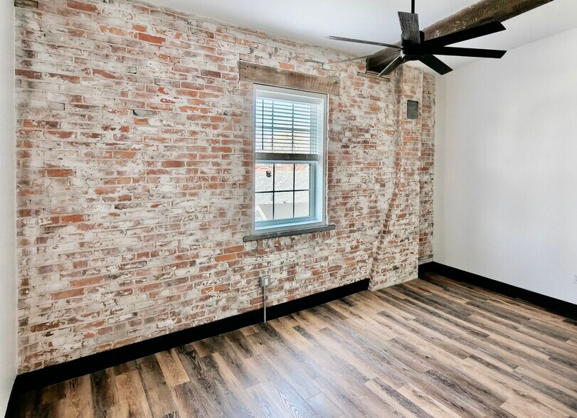 Primary bedroom features a queen size bed, a Smart TV, walk-in closet and en-suite bathroom. - 101 W Broadway St