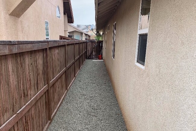 Side of house w/ 3 in of pea gravel & drains - 9219 Canyon View Ave