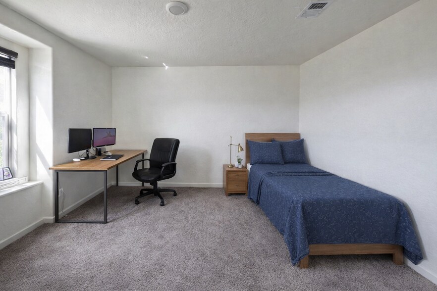 Furnished private bedroom with bed, desk, filing cabinet, and ample closet space - 719 Irma Dr