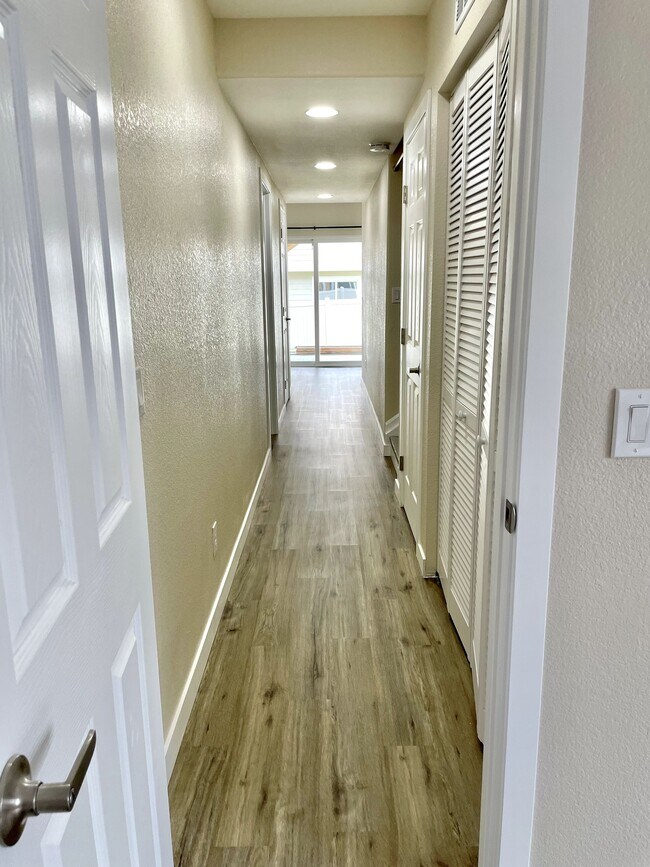 Hallway looking from main room down to entry. Recessed lighting throughout space - 12838 Arezzo Cir