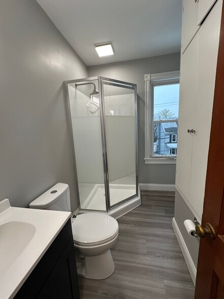 Newly renovated bathroom includes new shower, flooring, vanity, sink, toilet and fixtures - 115 E High St