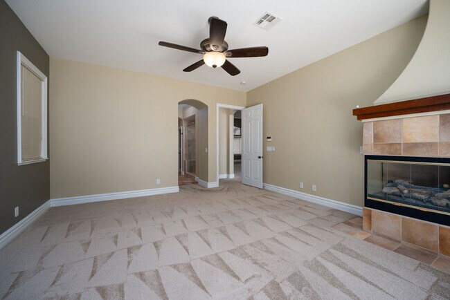 Relax after a long day in this huge primary bedroom with fireplace and sliding doors to the backyard - 2850 Bronzino Ct