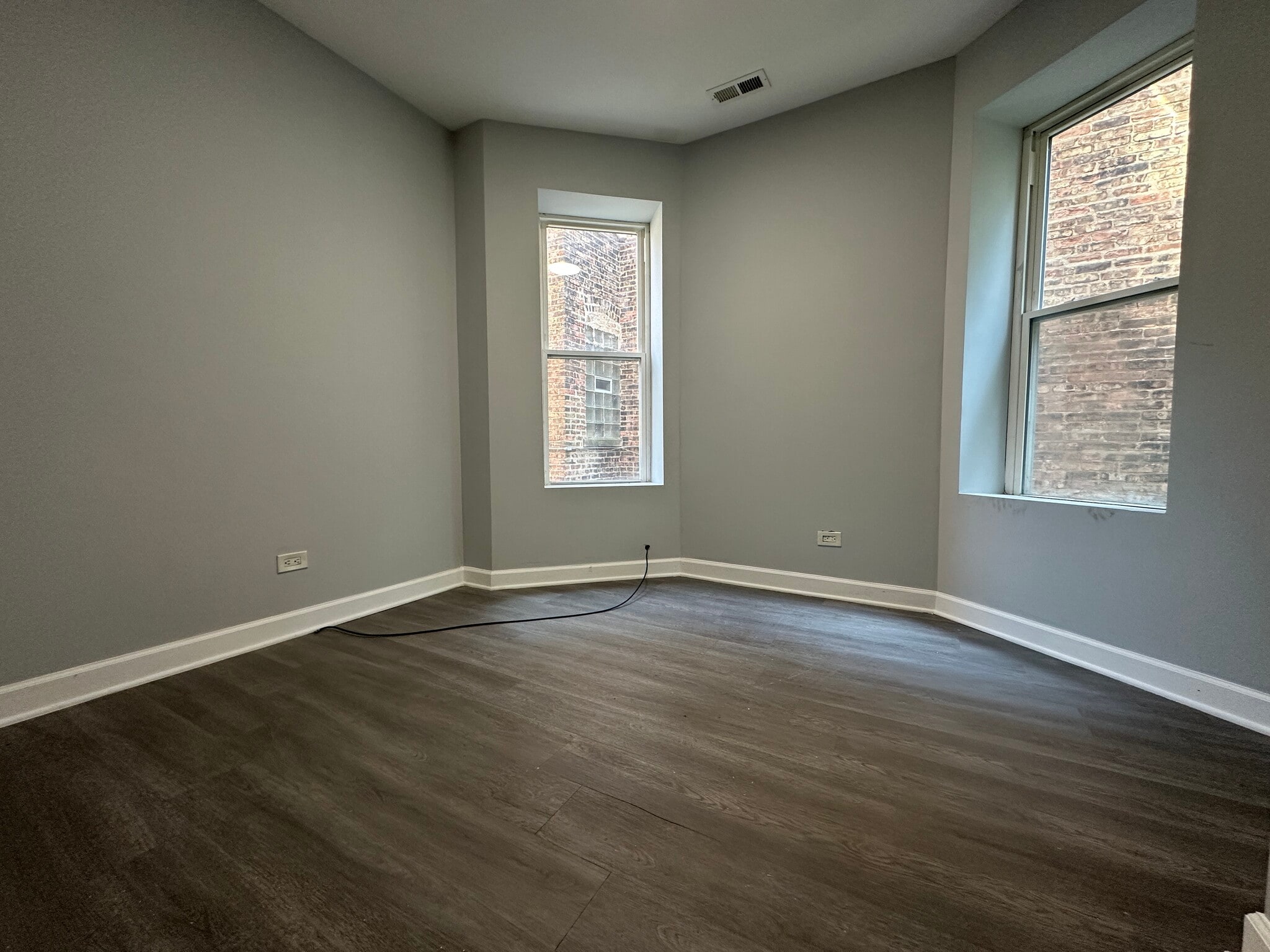 Large bedroom with big corner windows and brand-new flooring - 5653 S May St