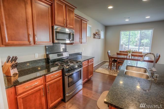 Kitchen and dining room, opens up to larger living room. - 8828 Jayden Ln NE