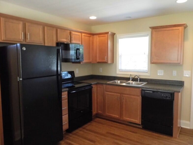 Beautiful kitchen with all NEW appliances, tons of cabinets, plenty of workspace, double stainless sink below a large window offering scenic views to the rear of the house - 2312-A Belle Ave NE