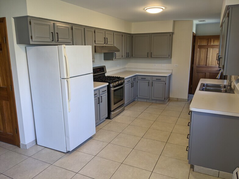 Kitchen with gas range, new hood vented to outside, and brand new microwave. - 509 Algonquin Rd