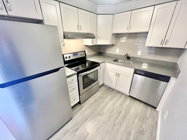 Step into a sleek, modern kitchen featuring top-of-the-line stainless steel appliances. - Oak Street Apartments