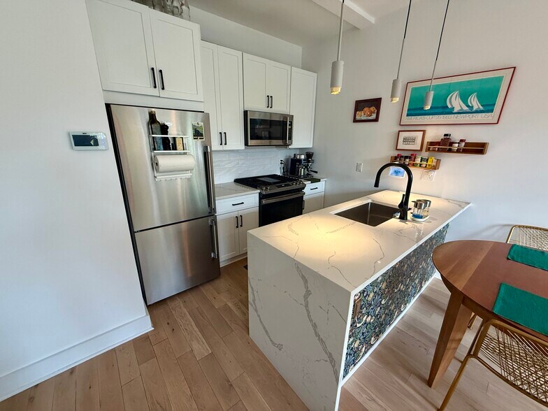 Kitchen with stainless steel appliances and quartz peninsula - 3916 14th St NW