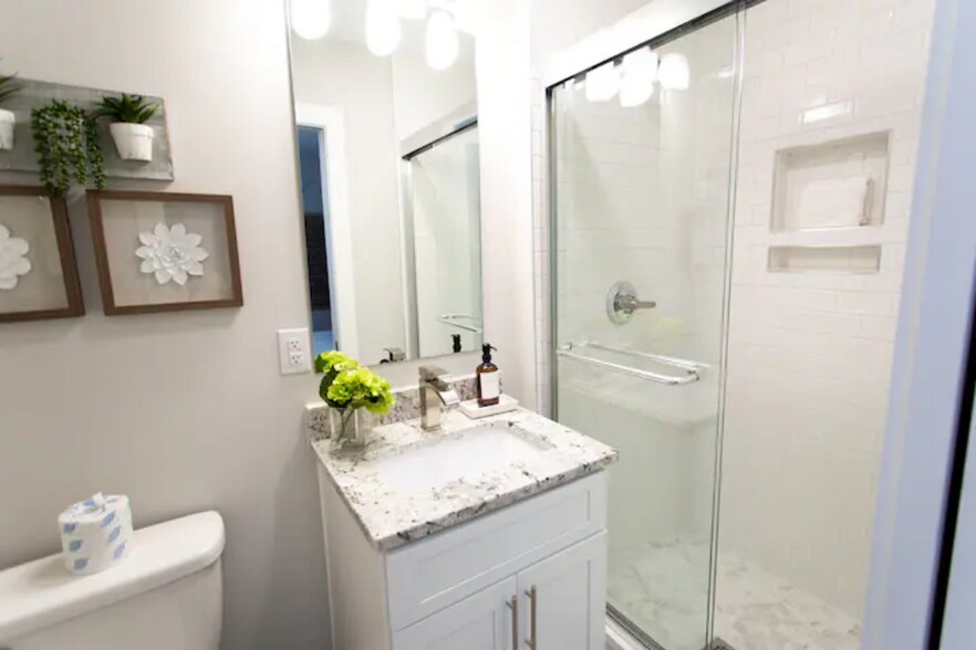 First-Floor Bathroom: Bright, modern bath with granite vanity and walk-in shower. - 421 Elysian Fields Rd