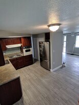 Kitchen with stainless steel French door refrigerator and dark wood cabinetry - 1147 Jennings Dr