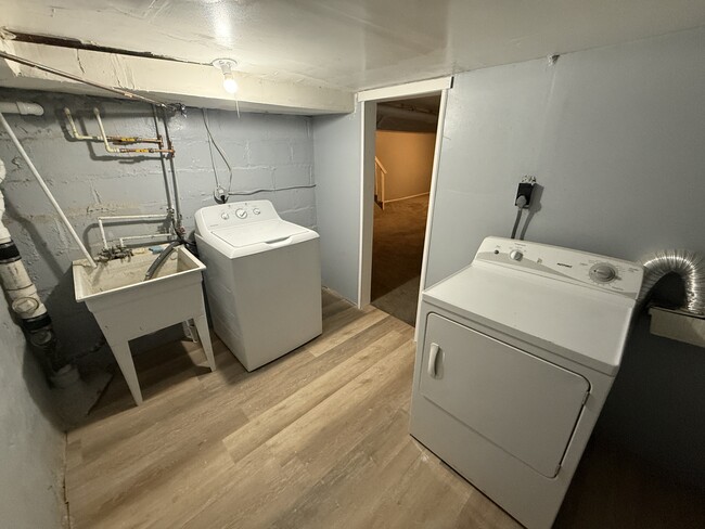 Laundry room with washer, dryer, and utility sink. - 606 N Woodington Rd