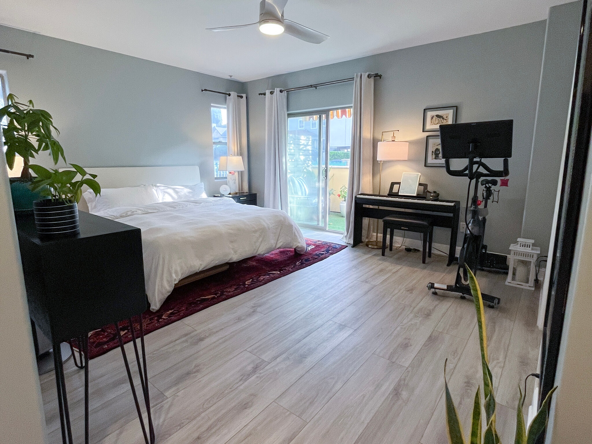 Primary bedroom with California King size bed, peloton, piano. Room for a desk if needed. - 5037 Rosewood Ave