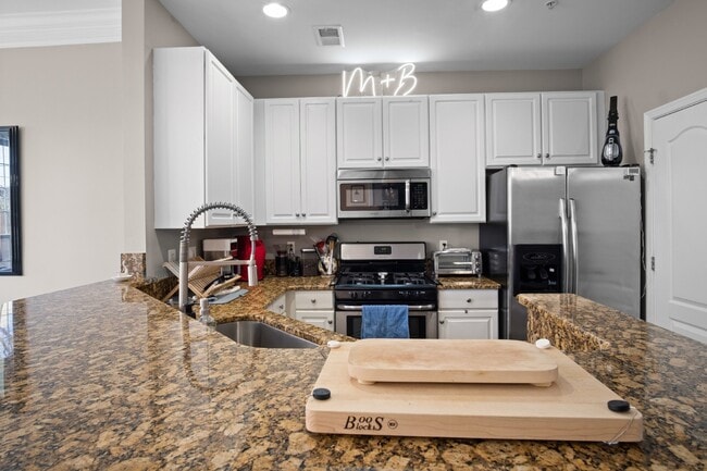 Building Photo - This inviting two-level townhome offers comfort and style, featuring gleaming hardwood floors on ...