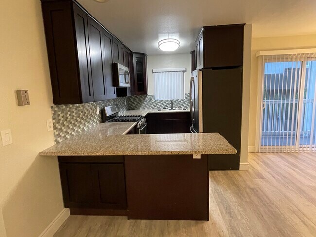 Rich chocolate cabinets, granite counters with room for bar stools. - 2411 Prospect Ave