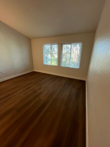 Master bedroom with mirrored closet doors with LVP and baseboards in closet - 16274 Avenida Venusto