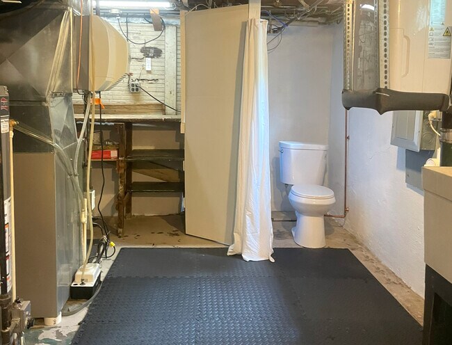 Second toilet and work bench in utility area of basement. - 3209 Atwood Ave