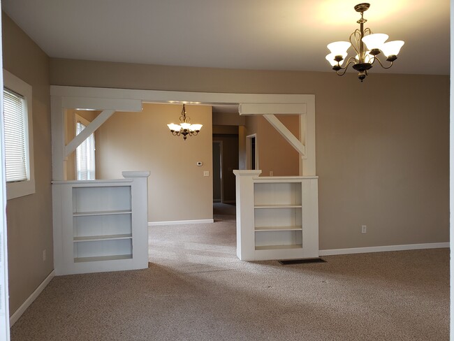 Living room has built in shelves, looking into dining room - 103 W 12th St