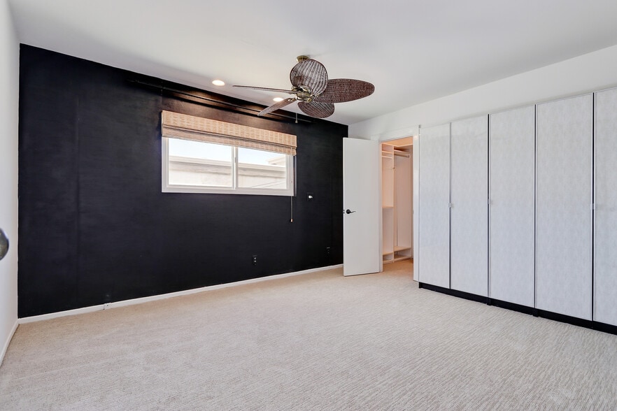 Striking grass cloth provides a dramatic backdrop for a king sized bed. - 744 12th St