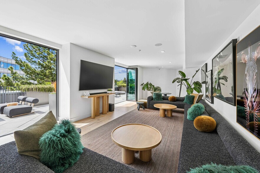 Bright and modern living room with stylish furniture, lush green plants, and a seamless flow to a sunlit outdoor patio. - The Rise Walnut Creek