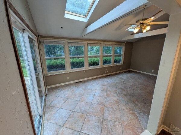 Sunroom with abundant natural light looks out on large fenced back yard. - 4515 West 72nd Terrace